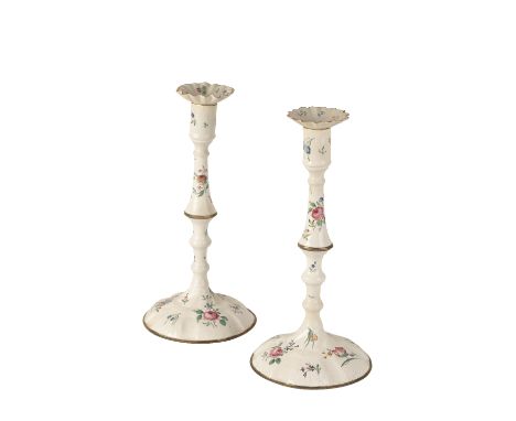 PAIR OF STAFFORDSHIRE ENAMEL CANDLESTICKS, 18TH CENTURY painted with brightly coloured flower sprays, reserved against a whit