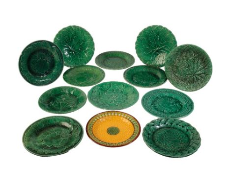 FOURTEEN MAJOLICA PLATES, 19TH CENTURY, thirteen in green glaze and one reticulated example in amber, green and brown, 22cm d