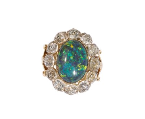 BLACK OPAL AND DIAMOND CLUSTER RING, the oval-cut opal with green hues, collet-set, surrounded by a border of twelve brillian