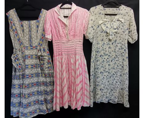 Three 1950s dresses, floral stripe with large patch pockets 96cm bust, pink camdystripe slight fading to the skirt 80cm bust 