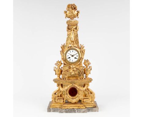 A wood sculptured clock in the shape of an obelisk. With an antique movement. 20th century. Dimensions: (W: 33 x H: 68 cm)