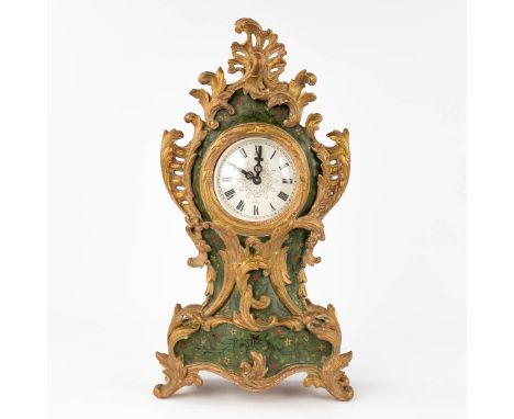 A wood-sculptured table clock in Louis XV style. The movement has been replaced by a vintage alarm clock. Dimensions: (W: 25 