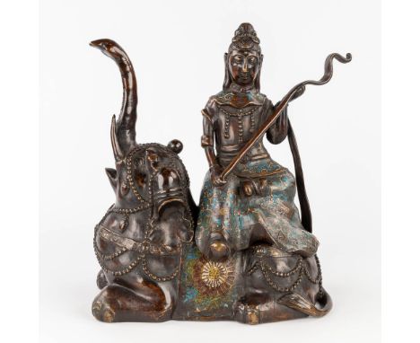 A figurine of Guanyin seated on an elephant, patinated bronze and champsleve enamel. 19th Century. Dimensions: (L: 15 x W: 30