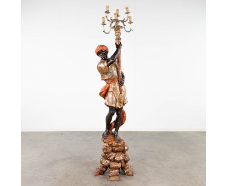 A blackamoor standing lamp, sculptured and patinated wood. 20th century. Dimensions: (H: 178 cm)