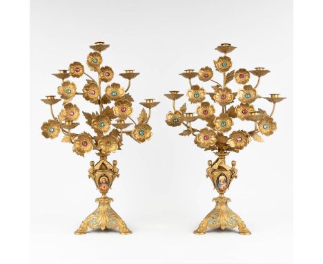 A pair of candelabra, gothic revival style, made of brass. Decorated with porcelain plaques of Christ with a sacred heart and