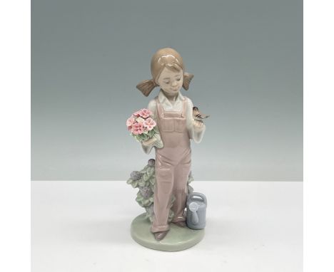 This charming Lladro porcelain Spring figurine, model number 01005217, depicts a young girl in pink overalls holding a bouque