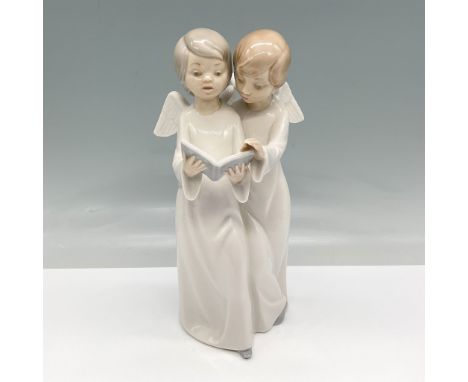 Nao by Lladro porcelain figurine depicting two angelic children reading from a book, designed with fine details and soft past