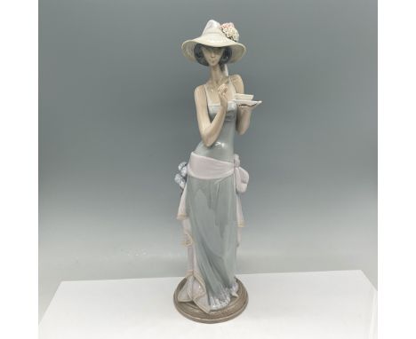 Lladro Tea Time figurine, model 01005470, depicts an elegant woman enjoying tea while dressed in a flowing pastel green and l