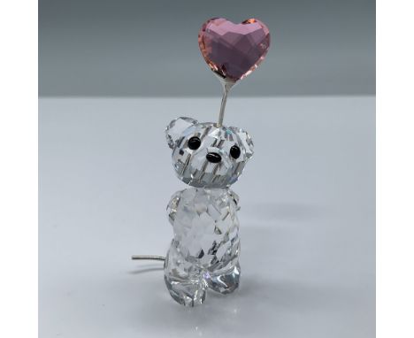 Swarovski Crystal Kris Bear with Heart Balloon figurine, crafted with precision-cut clear crystal. The bear holds a pink face