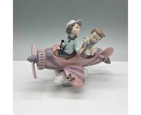 This delightful Lladro porcelain figurine, titled Don't Look Down (model number 01005698), features two children flying a whi