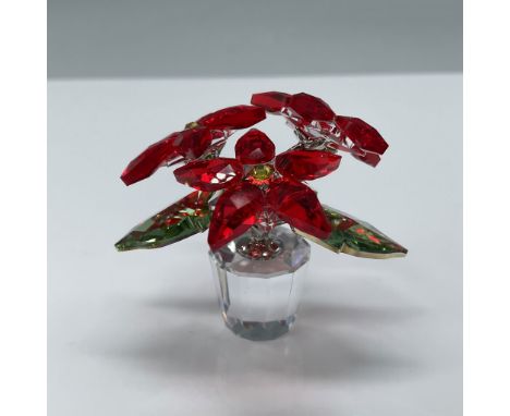 Swarovski crystal figurine depicting a vibrant red poinsettia flower in a faceted clear crystal pot. Measuring 2"H, this piec