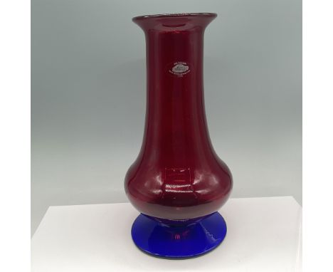 A vibrant Blenko handcrafted ruby red glass vase featuring a striking cobalt blue base. Known for its unique designs and vibr