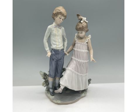 This exquisite Lladro porcelain figurine titled One, Two, Three (01005426) depicts a charming scene of a boy and girl steppin