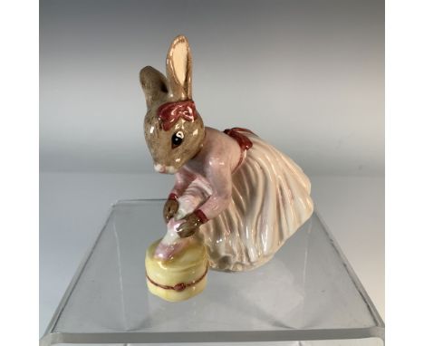 Charming Royal Doulton Bunnykins figurine titled Ballerina Bunnykins, featuring a young rabbit lacing up her ballet flat. Thi