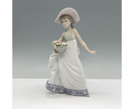 This is the Lladro Carefree figurine, model number 01005790. It features a young woman in a flowing white dress holding a bas