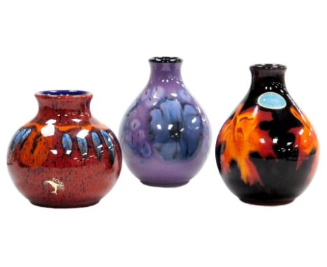 A Poole pottery Jasmine pattern vase, 13.5cm high, Forest Flame pattern vase, 13cm high, and a further vase in the Volcano pa