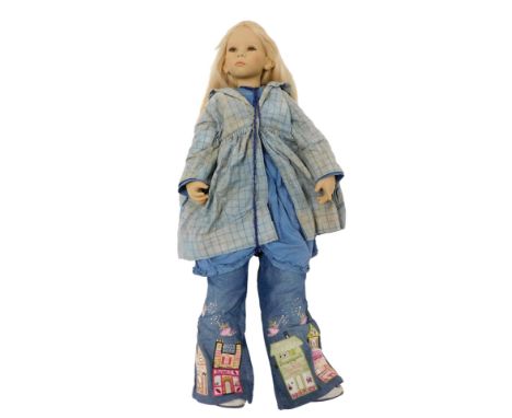 An Annette Himsteadt doll, wearing embroidered blue jeans, smock and overcoat, 92cm high.