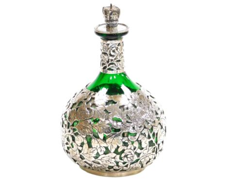 A late 19th/early 20thC Chinese green glass bottle, and stopper, with silver overlay of chrysanthemums, the stopper with crow