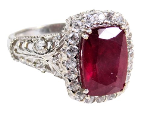 A ruby and CZ ring, the rectangle cut ruby in a surround of brilliant cut CZs, in a basket setting, white metal, stamped 925,
