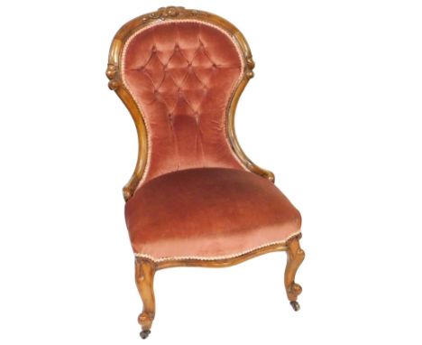 A Victorian walnut spoon back nursing chair, upholstered in button back red draylon, raised on cabriole legs, 56cm wide.
