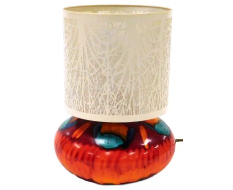 A Poole Pottery Volcano pattern table lamp, with a pierced cream metal shade, 32cm high.