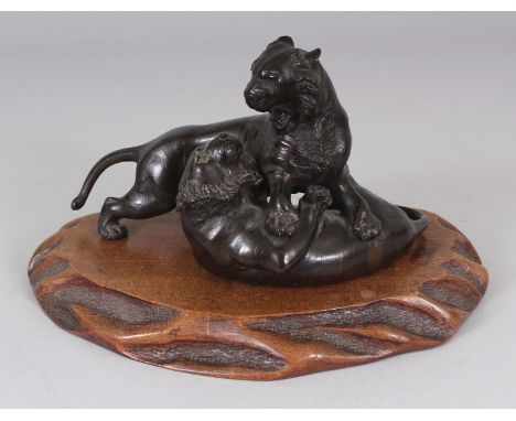 A GOOD QUALITY SIGNED JAPANESE MEIJI PERIOD BRONZE MODEL OF TWO FIGHTING TIGERS, together with a wood stand, the underside of