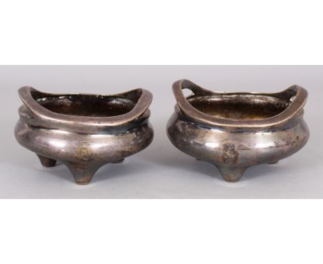 AN UNUSUAL PAIR OF 19TH CENTURY CHINESE SILVERED BRONZE TRIPOD CENSERS, one weighing 365gm, the other 450gm, each with uprigh