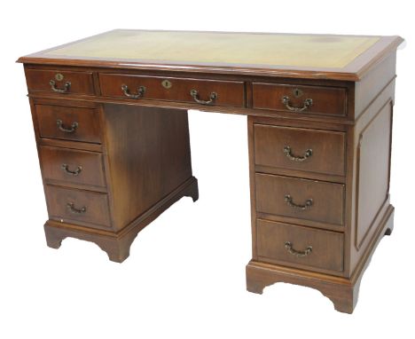 A 20thC pedestal desk, the rectangular overhanging top, set with a single piece of gilt tooled leather, raised above three fr