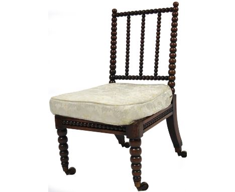 A Jacobean style walnut bobbin turned chair, with shaped back, turned forelegs terminating in castors, probably late 19thC, 9