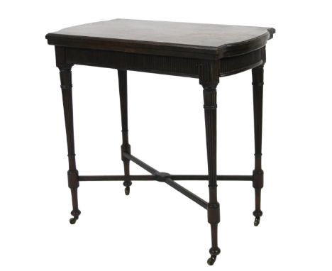 An Edwardian mahogany card table, the shaped top articulating and hinging to reveal a baize lined interior, above a carved fr