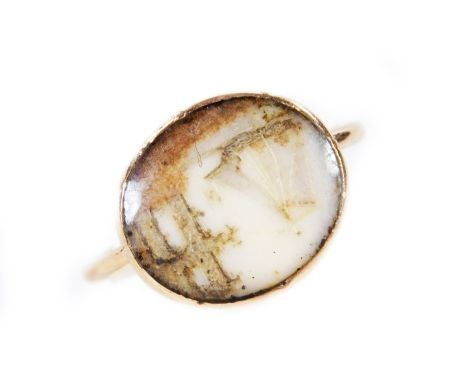 A 19thC dress ring, the oval centre decorated with boat before ruin, on a plain yellow metal shank, unmarked, size J.