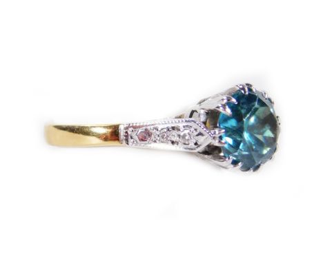 A dress ring, claw set with a blue stone, flanked by diamond shoulders, on a plain shank, size J-K, yellow metal, unmarked, p