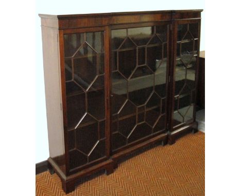 A late 19thC mahogany inverted breakfront bookcase, the moulded overhanging top raised above a central astragal glazed door, 