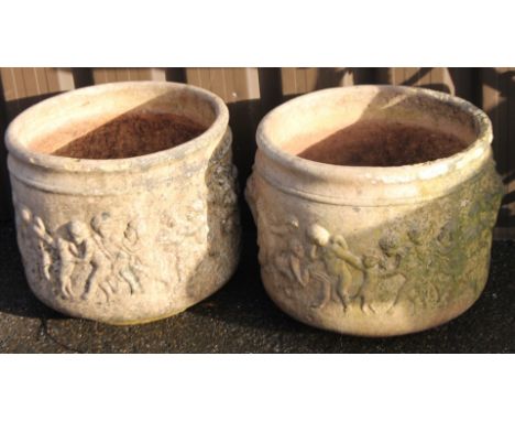 A pair of classical design stone garden planters, each of circular outline raised with various figures, with moulded lion rin