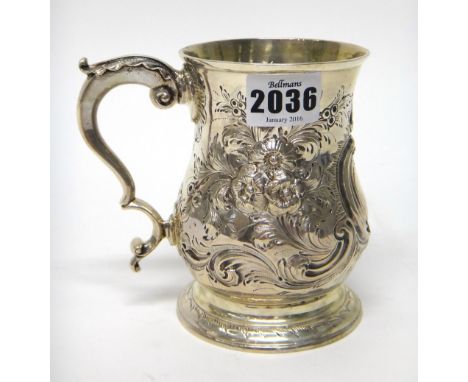 A George II silver mug, of baluster form, with later floral, foliate and scroll embossed decoration, crest engraved within a 