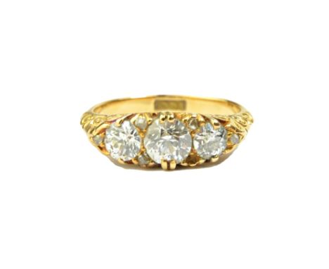 A gold and diamond set ring, mounted with a row of the three principal cushion shaped diamonds and with rose diamond points m