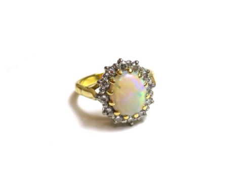 An 18ct gold, opal and diamond set oval cluster ring, claw set with the oval opal at the centre, within a surround of circula