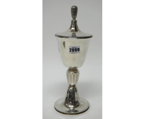 A silver cup and detachable cover, the stem of panelled form, with engraved decoration, on a circular foot, with a decorated 
