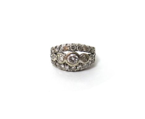 A diamond set ring, mounted with a row of five circular cut diamonds, graduating in size to the centre, within curved borders