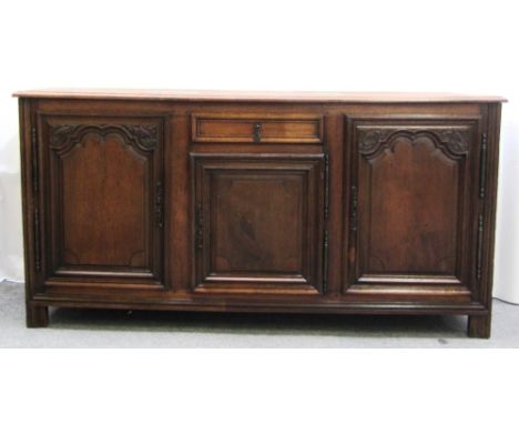 A late 18th/early 19th century French buffet, with single drawer and three shaped panel cupboards, on block feet, 199cm wide.