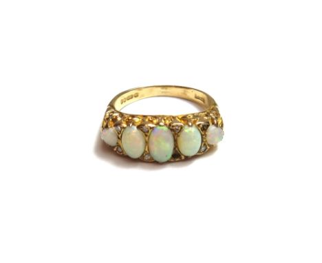 A 9ct gold and opal set five stone ring, mounted with a row of five graduated opals and with pairs of diamonds, mounted at in