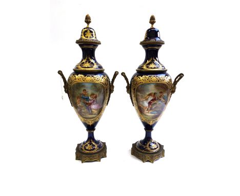 A pair of Sevres style ormolu mounted lidded porcelain vases, circa 1900, decorated with courting couples and cherubic figure