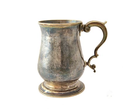 A George III silver mug, of baluster form, with a scrolling handle on a circular foot, London 1767, height 12cms, weight 329 