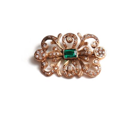 A rose coloured gold, diamond and synthetic emerald set brooch, mounted with the rectangular step cut synthetic emerald at th