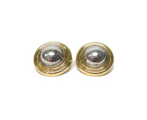 A pair of gold and silver earclips, each of circular form, having a domed silver centre within a wirework surround and with a