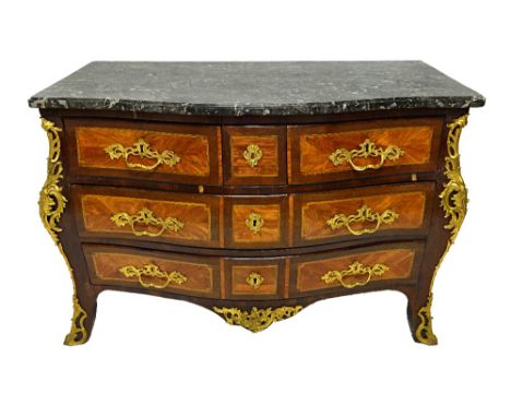 An early 19th century gilt metal mounted kingwood and padauk commode, the serpentine marble top over a bombe base of three sh