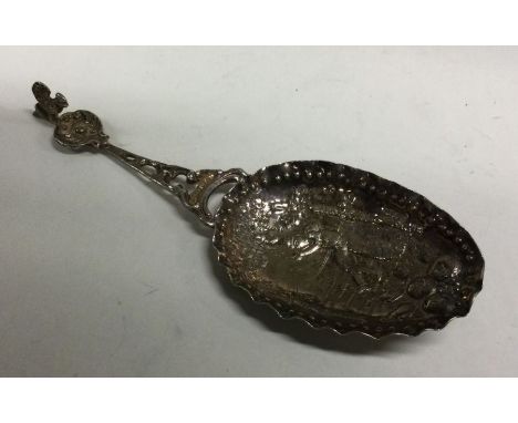 An oversized chased silver caddy spoon bearing German import marks. Approx. 35 grams. Est. £50 - £80.