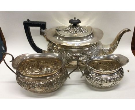 A good chased silver three piece tea service. Approx. 883 grams. Est. £300 - £400.