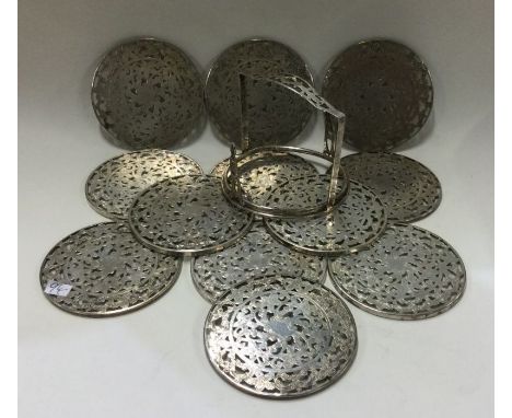 A set of twelve Sterling silver wine coasters in matching holder. Approx. 449 grams. Est. £80 - £120.