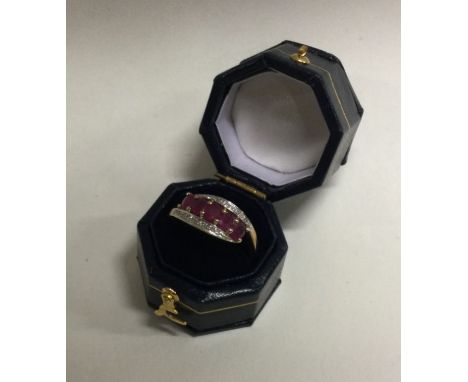 A ruby and diamond three row crossover ring in gold. Approx. 2.5 grams. Est. £200 - £300.